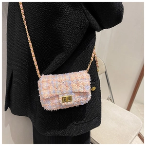Detail of tweed crossbody bag with gold turn-lock closure and woven chain strap