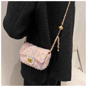Detail of pink and blue tweed crossbody bag with golden ball chain strap and metallic lock