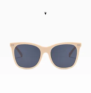 Detail view of beige sunglasses frame with smoke gray lenses and silver metal rivets