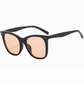 Close-up of black oversized cat-eye sunglasses with orange lenses and metal rivet detail