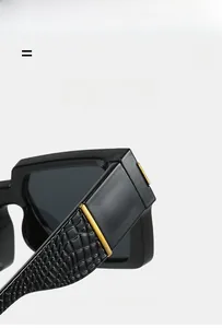 Detail of square sunglasses with black crocodile texture temples and gold metal accents