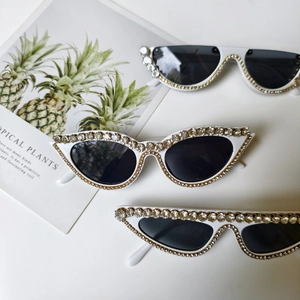 Drei Paar weiße, mit Strasssteinen besetzte Sonnenbrillen in Cat-Eye- und Retro-Stilen