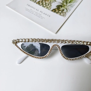Detailansicht der weißen Cat-Eye-Sonnenbrille mit luxuriösem Strass auf weißem Hintergrund