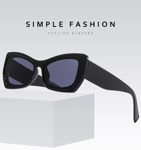 Detail of thick black cat-eye sunglasses frames and wide temples on a white pedestal