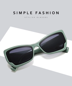 Detail view of sage green thick rectangle frame sunglasses with dark grey lenses