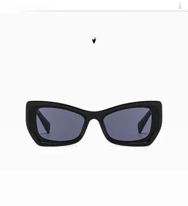 Detail of glossy black cat-eye sunglasses with thick retro frame and dark grey lenses