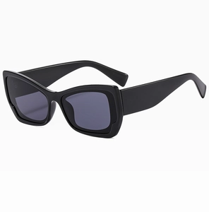 Detail shot of black cat-eye sunglasses with wide temples and high-gloss plastic finish