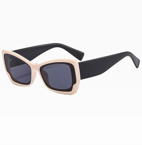 Detail of trendy square-frame sunglasses featuring two-tone cream and black bold temples