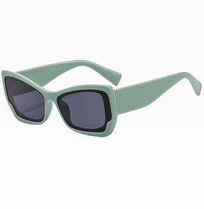 Detail of light green cat eye sunglasses with black inner trim and dark UV lenses