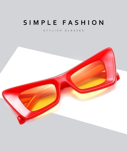 Détail de lunettes de soleil œil-de-chat rouges avec verres orange et monture épaisse