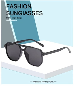Detail view of black oversized sunglasses with thick frames and metal hinge dots