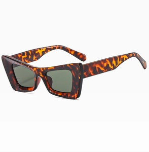 Vue détaillée des lunettes de soleil œil de chat écaillé avec verres vert foncé sur blanc
