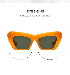 Close-up of bright orange cat-eye sunglasses with dark grey lenses and thick frames