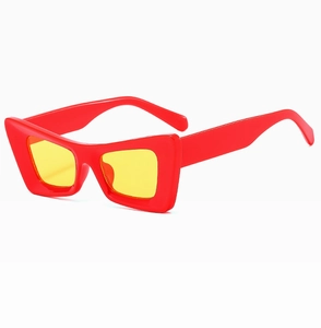 Gros plan de lunettes de soleil rouges à monture épaisse avec verres jaunes rétro