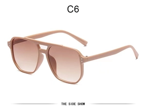 Detail of beige pilot sunglasses with brown gradient lenses and silver rivet accents