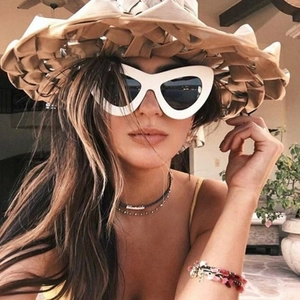 Fashionable oversized ivory cat-eye sunglasses with dark grey lenses on model