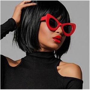 Close-up of red oversized cat-eye sunglasses with dark lenses worn by a fashion model