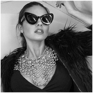 Fashion model wearing chic cat-eye sunglasses and luxury multi-layer rhinestone body chain