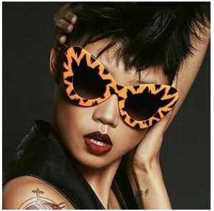 Close-up of cat-eye sunglasses with orange and black flame pattern on a model