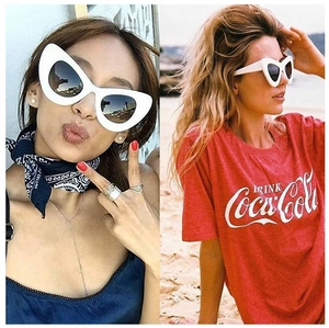 Close-up of stylish white cat-eye sunglasses with dark grey lenses on female models
