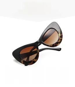 Detail of oversized cat eye sunglasses with leopard print frame and amber gradient lenses