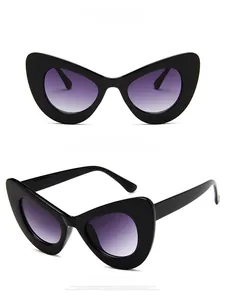 Detail view of glossy black oversized cat-eye sunglasses with purple gradient lenses