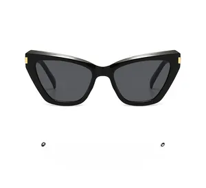 Détail de lunettes de soleil oeil de chat noires avec charnière en métal doré
