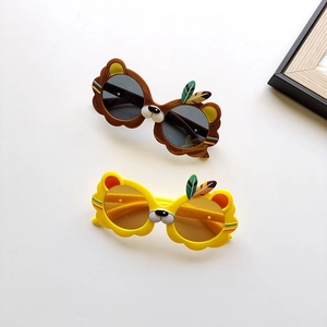 Détail de lunettes de soleil lion pour enfants en jaune et marron avec plumes décoratives
