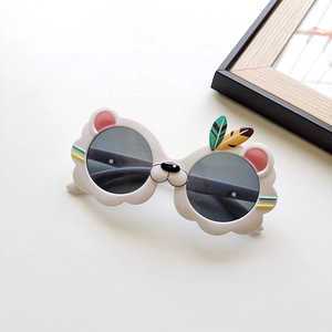 Détail de lunettes de soleil lion pour enfants avec plumes colorées et verres gris