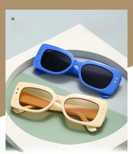 Detail of square polarized sunglasses featuring gold star rivets on blue and beige frames