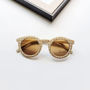 Detail of round kids sunglasses with yellow checkerboard frame and UV400 protection