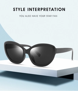 Detail of black cat-eye sunglasses with wide temples on a clean geometric stand