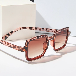 Stylish square leopard print sunglasses with brown gradient lenses on white display blocks