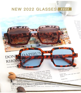 Close-up of leopard square frame sunglasses with blue and tea tinted lenses on a magazine