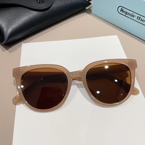 Macro detail of amber brown retro sunglasses with deep tea lenses and leather case