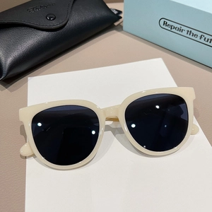 Retro oversized beige sunglasses with black lenses and leather case on a textured background
