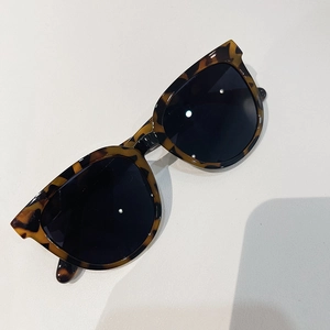 Top view of oversized tortoiseshell sunglasses with vintage cat-eye frames and dark lenses