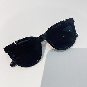 Close-up of oversized black square sunglasses with dark lenses on a white background