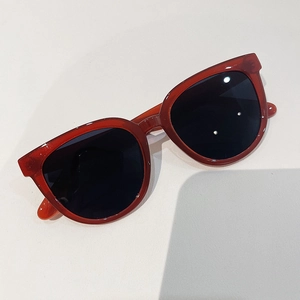 Detail view of vintage dark red acetate frame sunglasses with classic grey lenses
