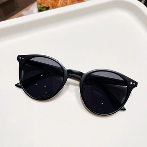 Vue détaillée de lunettes de soleil rondes rétro avec monture noir mat et rivets en argent