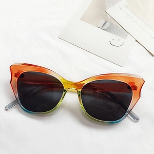 Detailansicht der Cat-Eye-Sonnenbrille mit orange-türkisem Farbverlauf auf weißem Tuch