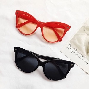 Lunettes de soleil œil-de-chat rouges et noires avec détails en métal sur tissu blanc