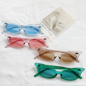 Set of four colorful cat-eye sunglasses with transparent frames on a white fabric backdrop