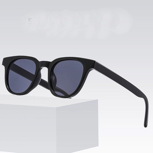 Classic black resin square sunglasses with dark grey lenses shown on white geometric block