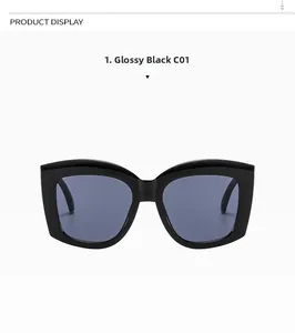 Detail view of glossy black oversized sunglasses featuring dark blue lenses and wide frame