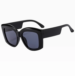 Close-up of oversized black resin sunglasses frame with wide temples and dark lenses