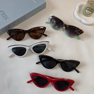 Lunettes de soleil œil de chat rétro en plusieurs couleurs acidulées sur fond lifestyle