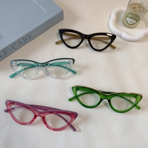 Vue à plat de montures de lunettes œil de chat vintage en noir, vert et rose pastel
