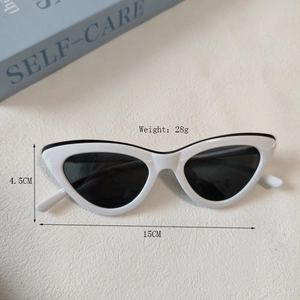Lunettes de soleil œil de chat blanches avec verres noirs sur un livre de soins