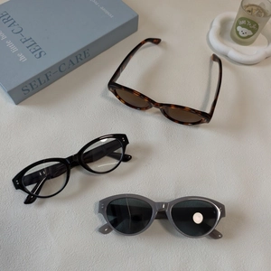 Flat lay of retro resin cat eye sunglasses with metal rivets on minimalist background